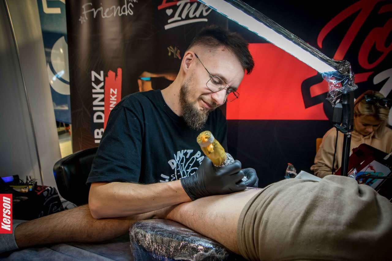 Dinozaur i logo DINKZ ART na konwencie tatuażu Dinozaur i logo DINKZ ART na konwencie tatuażu